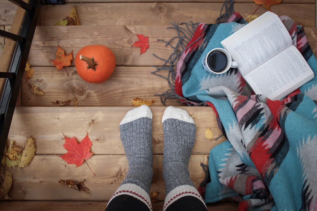 Gezellige leeshoek met herfstbladeren en warme plaid. Gezellige leeshoek met herfstbladeren en warme plaid.